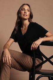 Model Madeline wearing size S of The Transeasonal Short Sleeve Jumper in colour Black (Black), from the front, showing the whole outfit