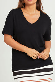 Model Monique wearing size L of The Transeasonal Short Sleeve Jumper in colour Black (Black), from the front, cropped image