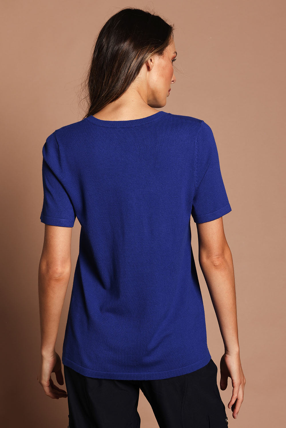 Model Madeline wearing size S of The Transeasonal Short Sleeve Jumper in colour Bluetopaz (Blue), from the back