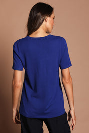 Model Madeline wearing size S of The Transeasonal Short Sleeve Jumper in colour Bluetopaz (Blue), from the back