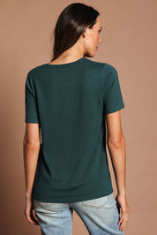 Model Madeline wearing size S of The Transeasonal Short Sleeve Jumper in colour Peacock (Green), from the back