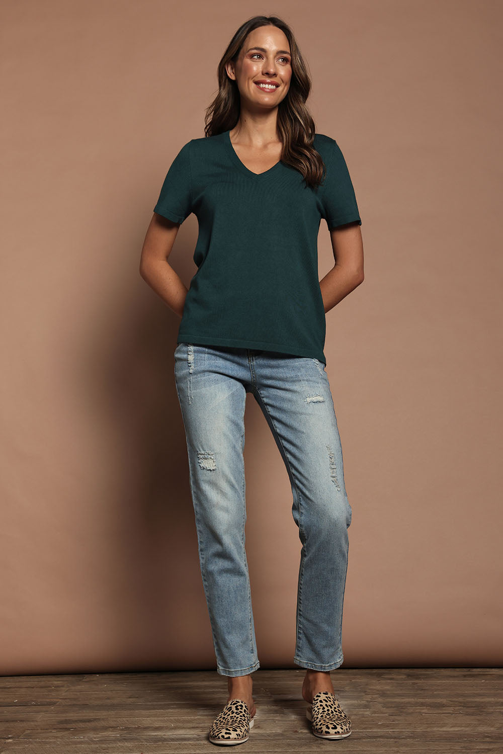 Model Madeline wearing size S of The Transeasonal Short Sleeve Jumper in colour Peacock (Green), from the front, showing the whole outfit