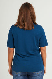Model Monique wearing size L of The Transeasonal Short Sleeve Jumper in colour Petrol (Blue), from the back