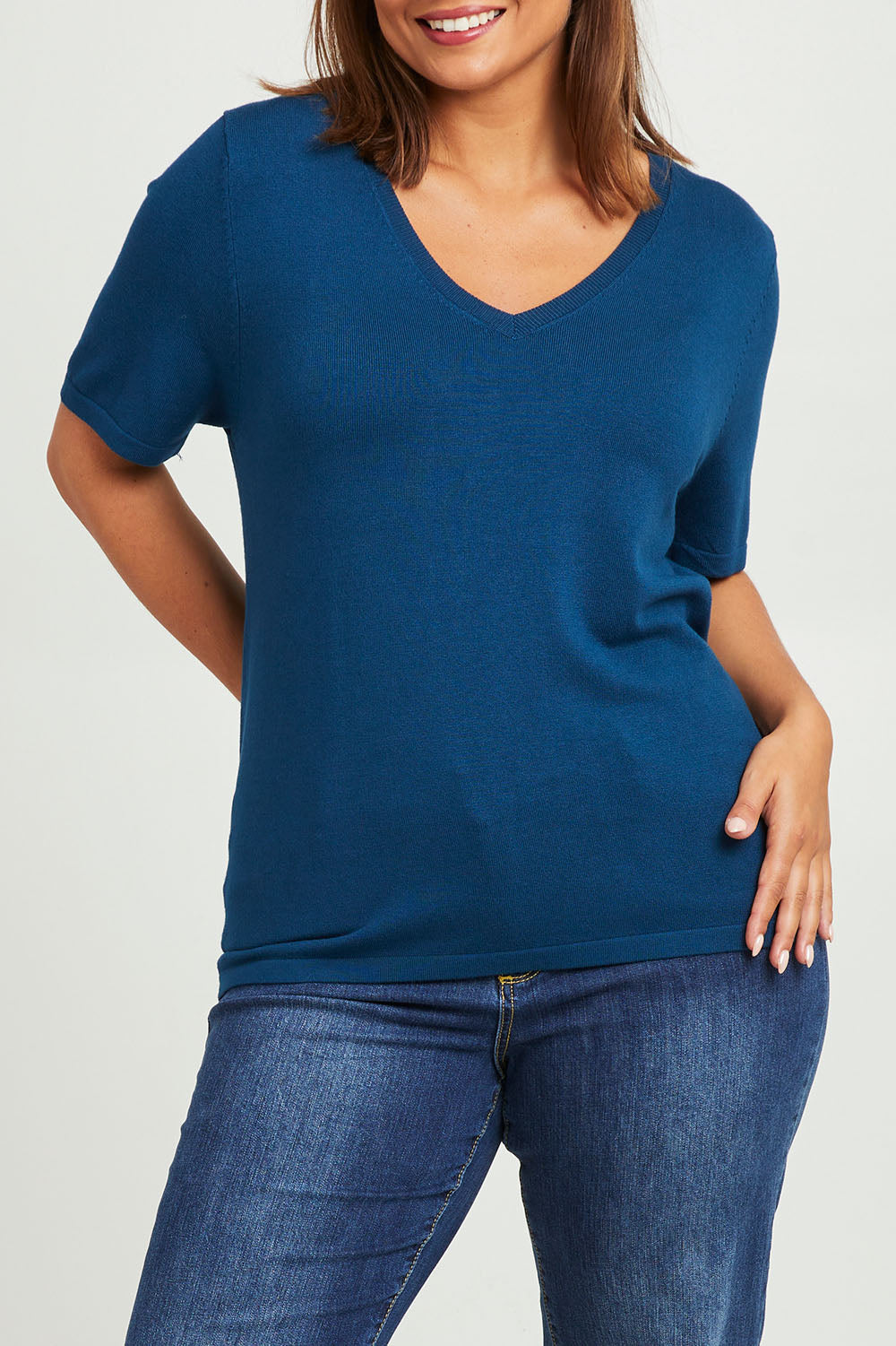 Model Monique wearing size L of The Transeasonal Short Sleeve Jumper in colour Petrol (Blue), from the front, cropped image