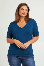 Model Monique wearing size L of The Transeasonal Short Sleeve Jumper in colour Petrol (Blue), from the front, cropped image