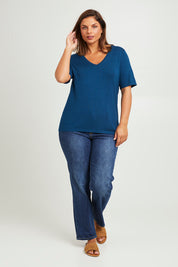 Model Monique wearing size L of The Transeasonal Short Sleeve Jumper in colour Petrol (Blue), from the front, showing the whole outfit