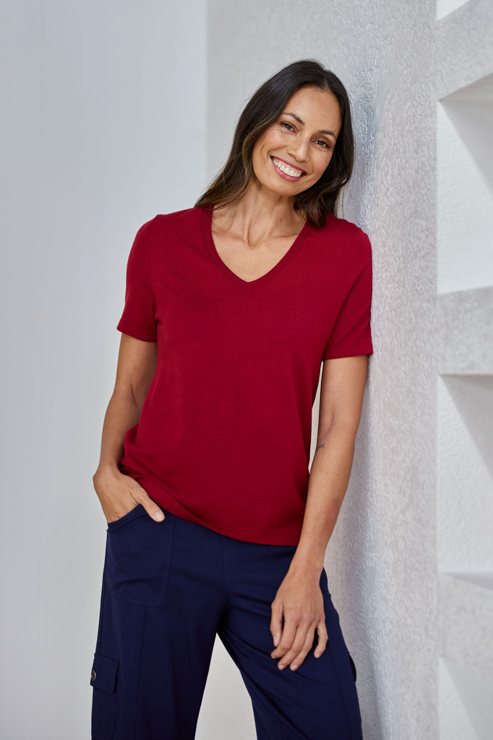 Model Amanda wearing size S of The Transeasonal Short Sleeve Jumper in colour Raspberry (Red), from the front, showing the whole outfit
