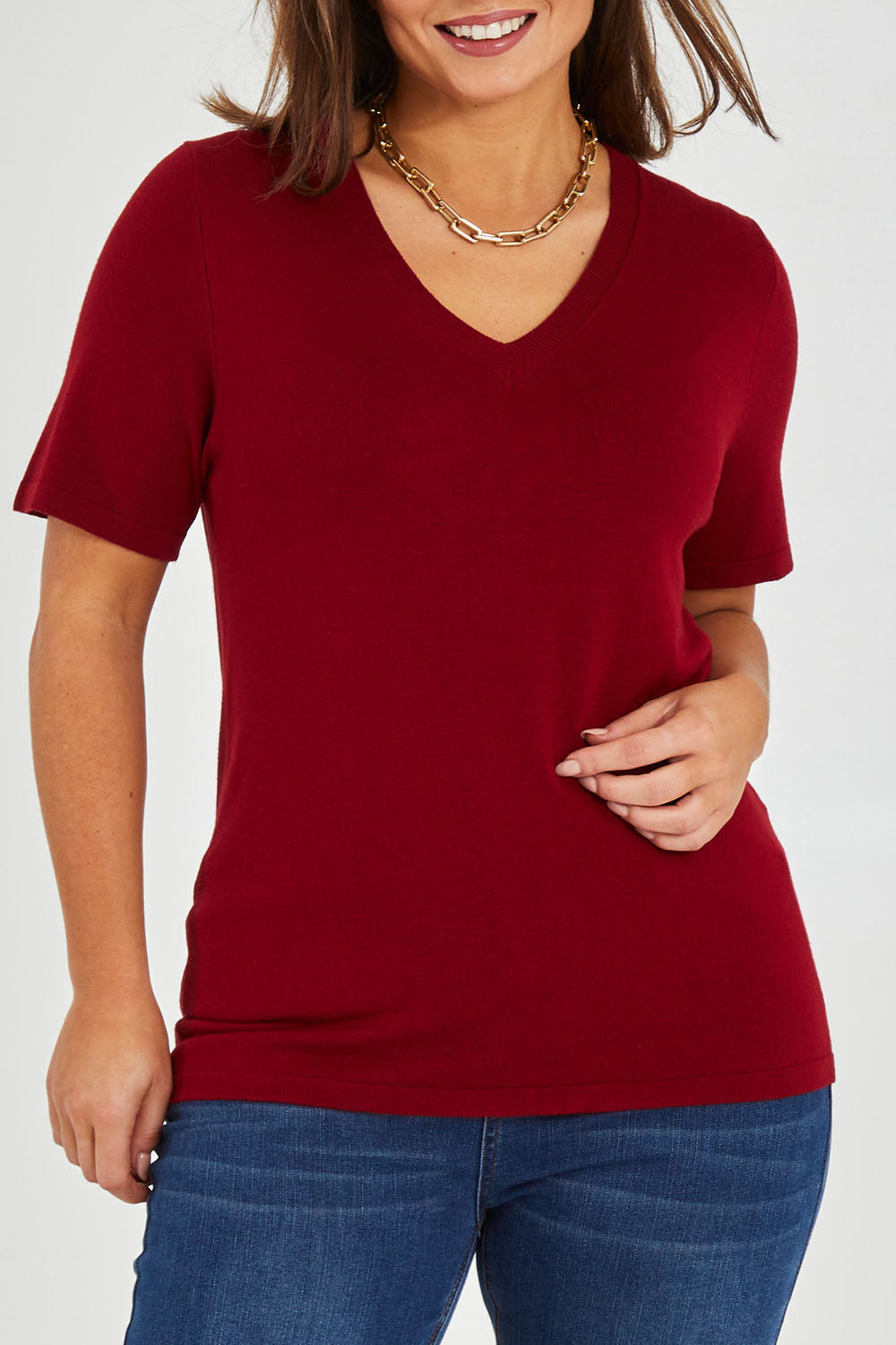 Model Monique wearing size L of The Transeasonal Short Sleeve Jumper in colour Raspberry (Red), from the front, cropped image