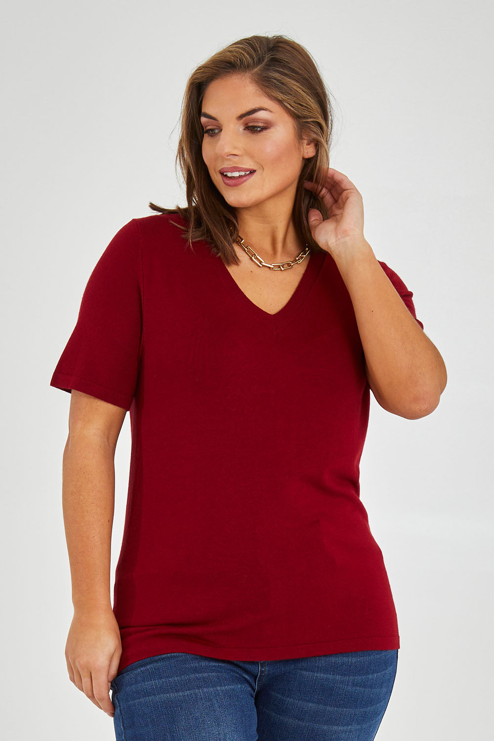 Model Monique wearing size L of The Transeasonal Short Sleeve Jumper in colour Raspberry (Red), from the front, cropped image