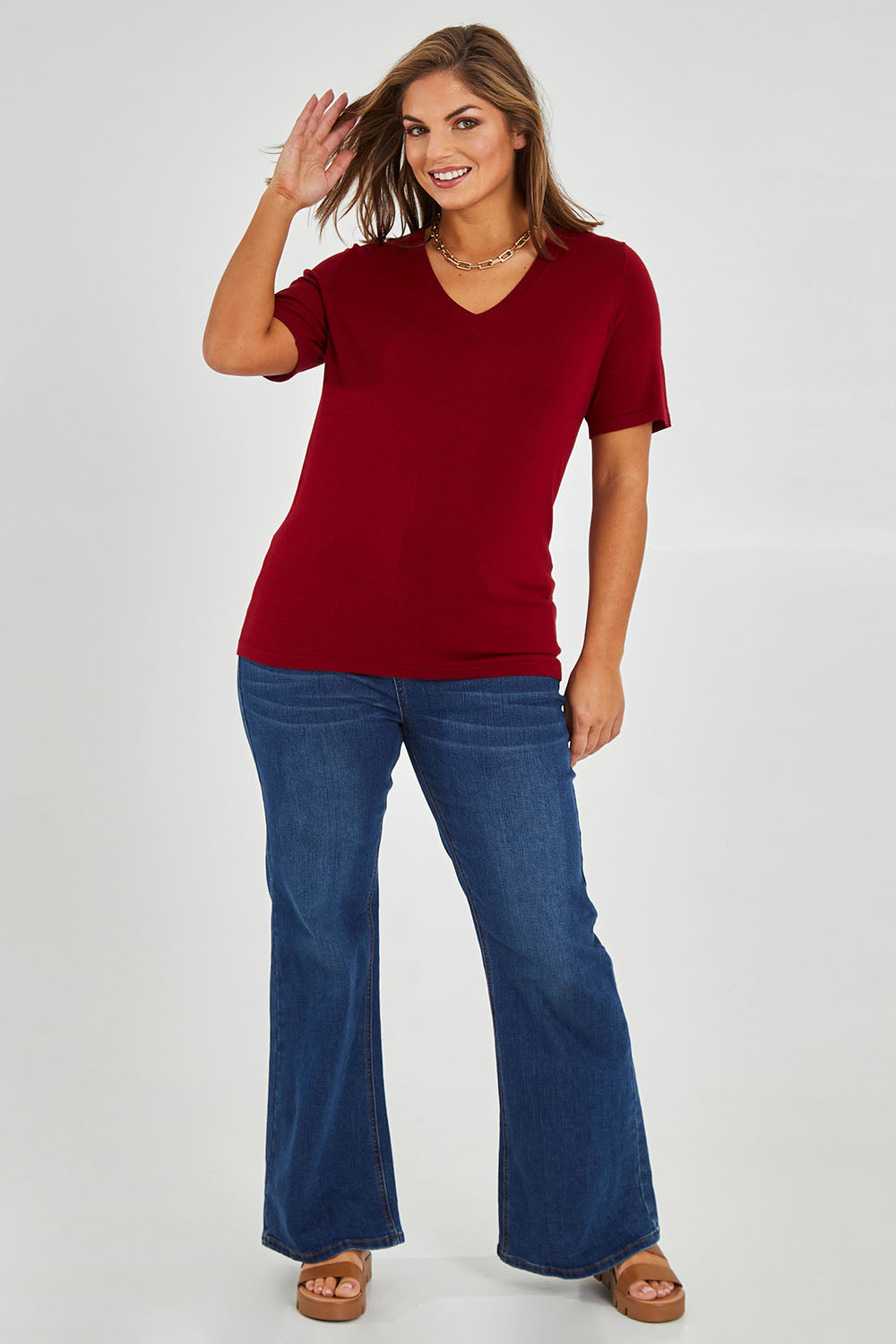 Model Monique wearing size L of The Transeasonal Short Sleeve Jumper in colour Raspberry (Red), from the front, showing the whole outfit