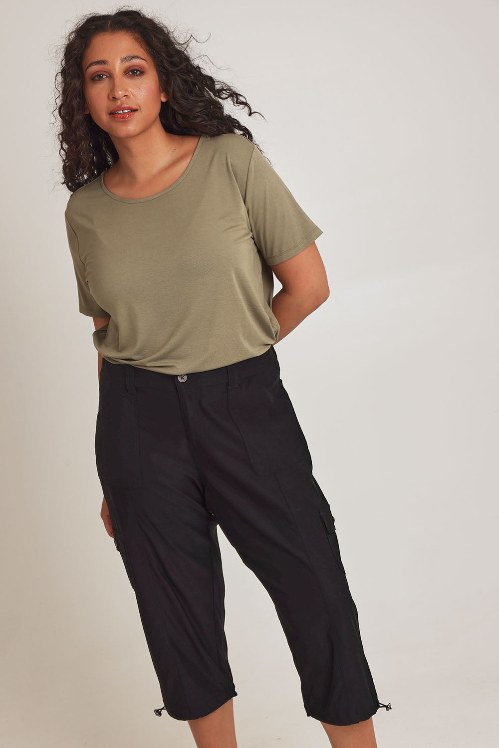 Model Terri-Leigh wearing size 14 of The Everyday Cropped Cargo Pant in colour Black (Black), from the front, cropped image