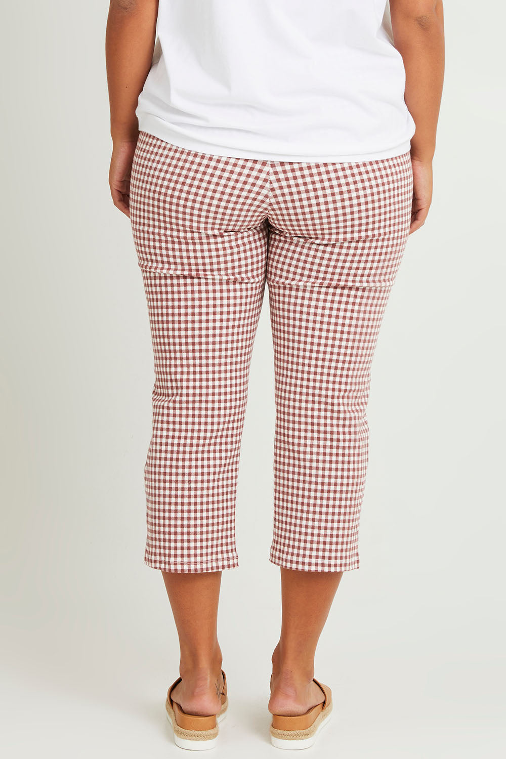 Model Monique wearing size 14 of The Check Pull On Pant in colour Dustyrose (Pink), from the back
