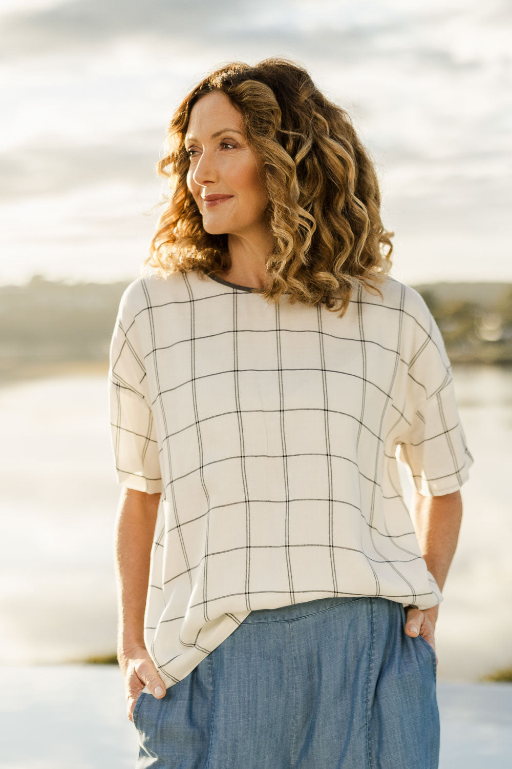 Model Emma wearing size 10 of The Keepers Relax Fit Top in colour Ivorygrey (White), from the front, showing the whole outfit