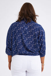 Model Monique wearing size 14 of The Keepers Batwing Shirt in colour Navyfloral (Blue), from the back