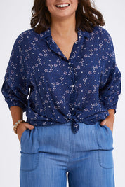 Model Monique wearing size 14 of The Keepers Batwing Shirt in colour Navyfloral (Blue), from the front, cropped image