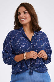 Model Monique wearing size 14 of The Keepers Batwing Shirt in colour Navyfloral (Blue), from the front, cropped image