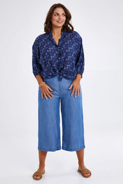 Model Monique wearing size 14 of The Keepers Batwing Shirt in colour Navyfloral (Blue), from the front, showing the whole outfit