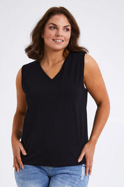 Model Monique wearing size 14 of The Keepers Cotton Tank in colour Black (Black), from the front, cropped image
