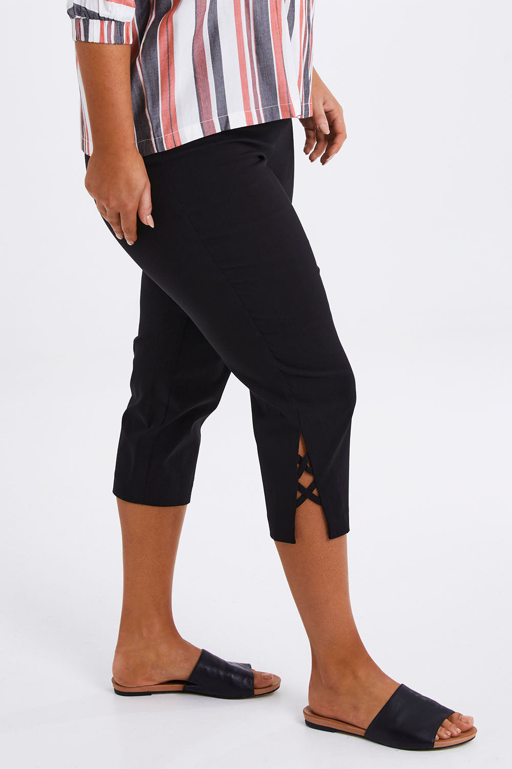 Model Monique wearing size 14 of The X Detail Capri Pant in colour Black (Black), from the front, cropped image