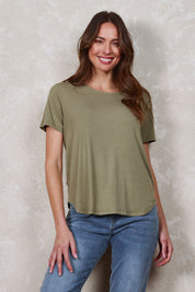 Model Madeline wearing size 10 of The Bamboo Curved Hem Tee in colour Khaki (Green), from the front, showing the whole outfit