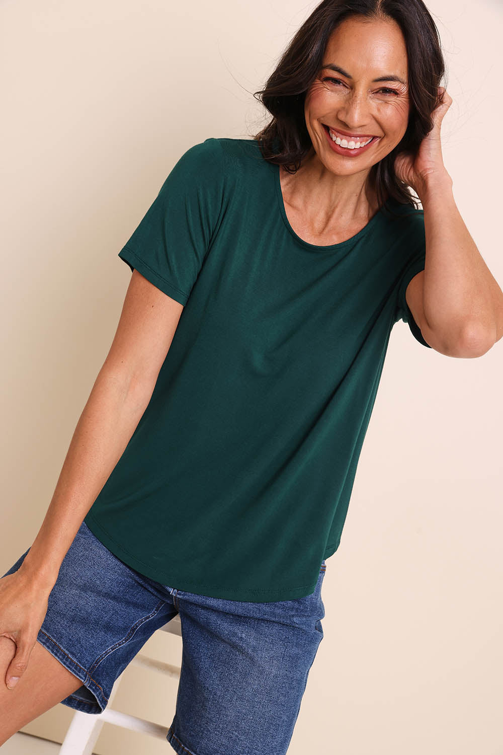 Model Amandam wearing size 10 of the The Bamboo Curved Hem Tee – Forest in colour Forest, in a cropped view
