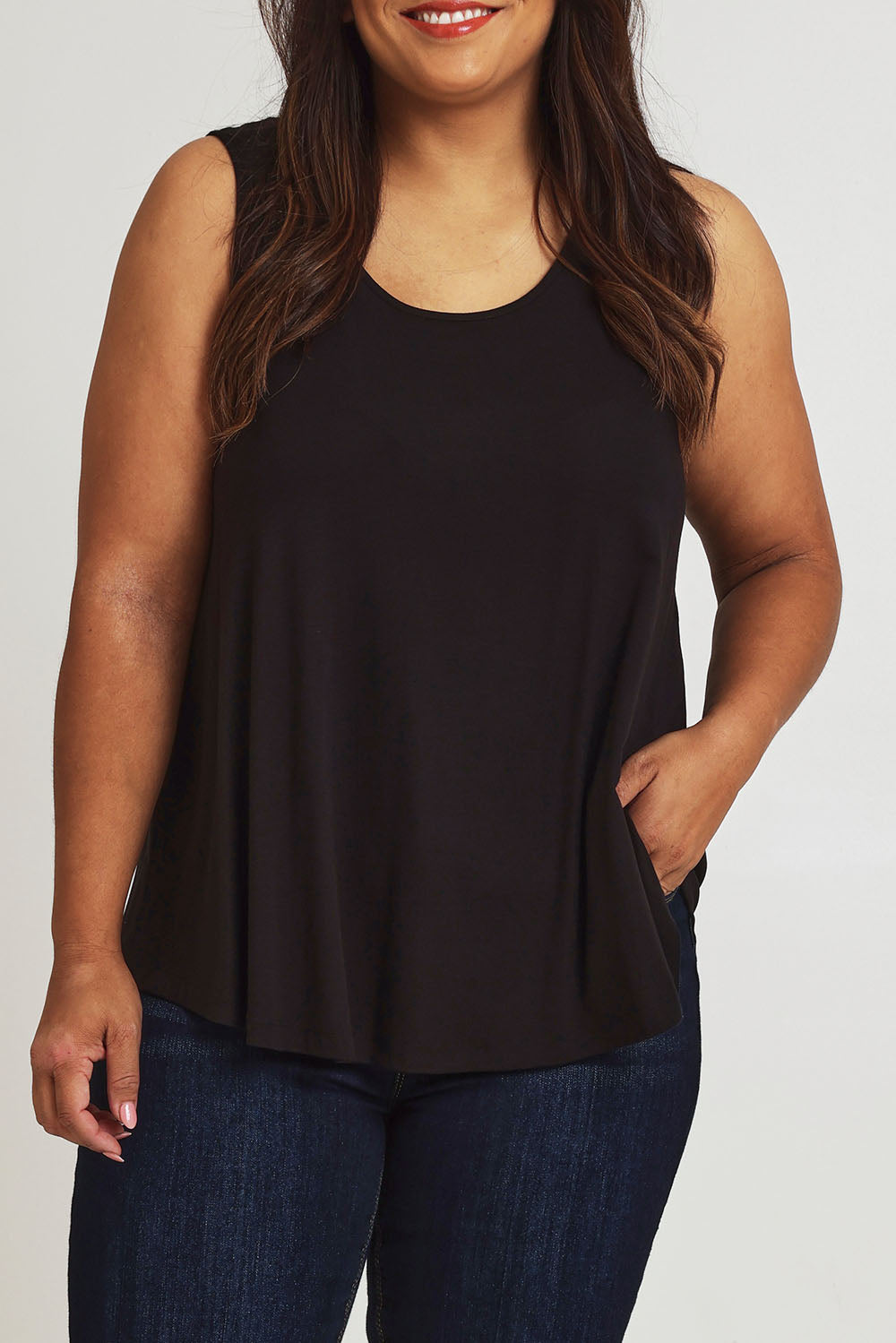 Model Ashleigh wearing size 16 of The Bamboo Crew Neck Swing Tank in colour Black (Black), from the front, cropped image
