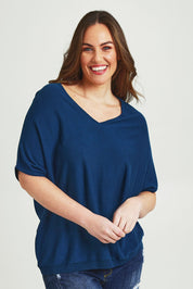 Model Jane wearing size L of The Relaxed V Neck Knit Tee in colour Petrol (Blue), from the front, cropped image