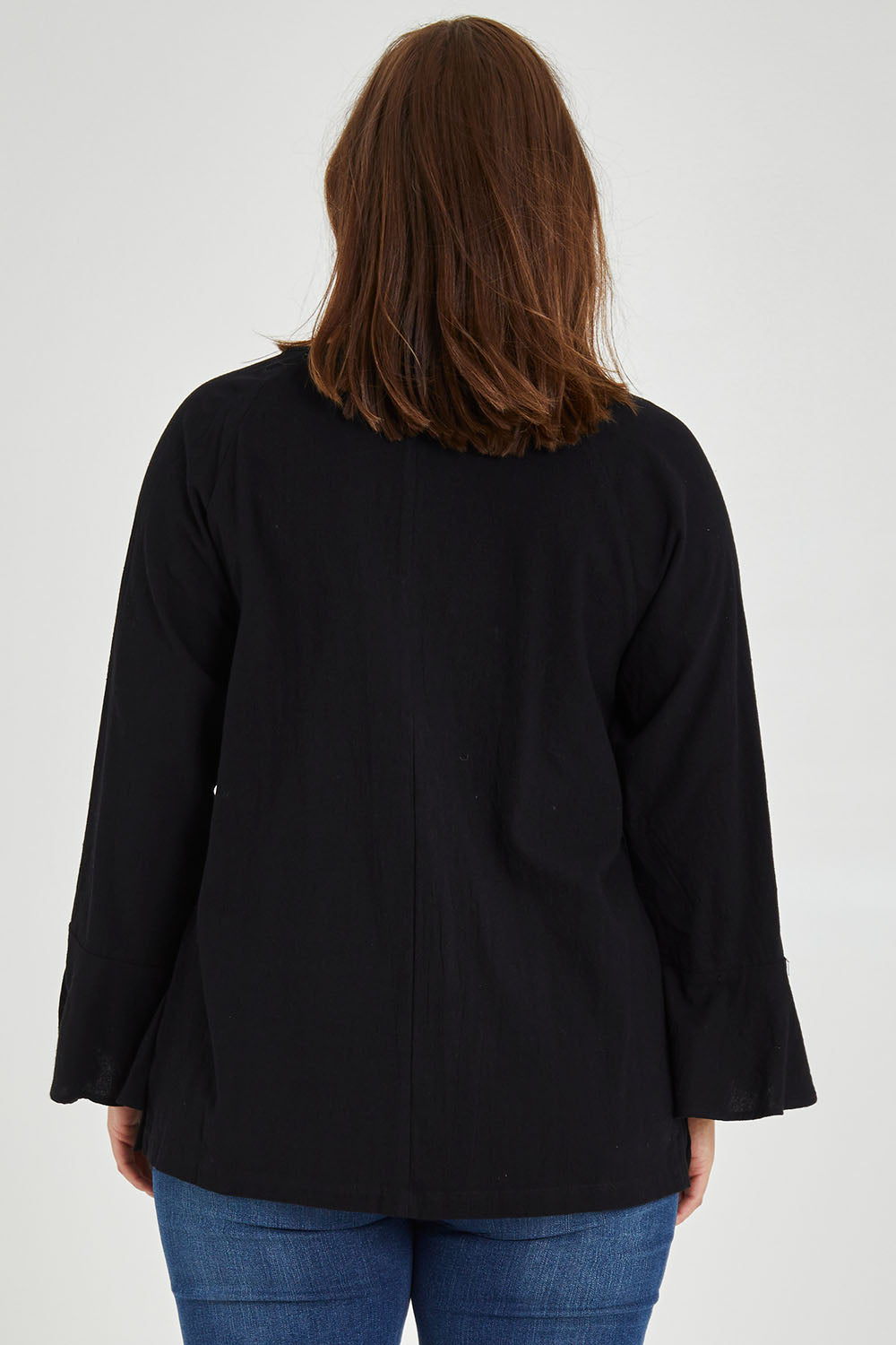 Model Monique wearing size 14 of The Fluted Sleeve Top in colour Black (Black), from the back