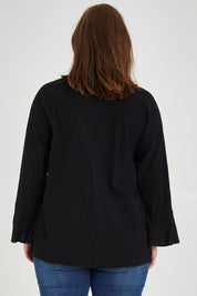 Model Monique wearing size 14 of The Fluted Sleeve Top in colour Black (Black), from the back