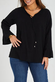 Model Monique wearing size 14 of The Fluted Sleeve Top in colour Black (Black), from the front, cropped image