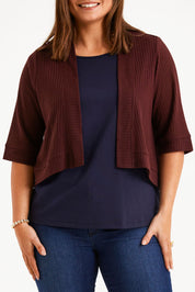 Model Monique wearing size 14 of The Textured Shrug in colour Mulberry (Purple), from the front, cropped image