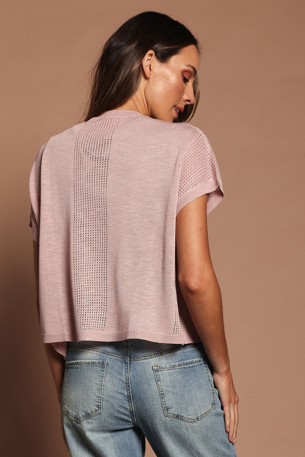 Model Madeline wearing size S of The Short Sleeve Shrug in colour Blushpink (Pink), from the back