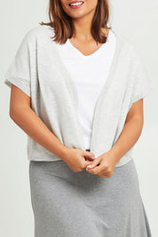 Model Monique wearing size L of The Short Sleeve Shrug in colour Greymarle (Grey), from the front, cropped image