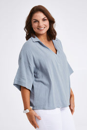 Model Monique wearing size 14 of The Double Cotton Collar Top in colour Chambray (Blue), from the front, cropped image