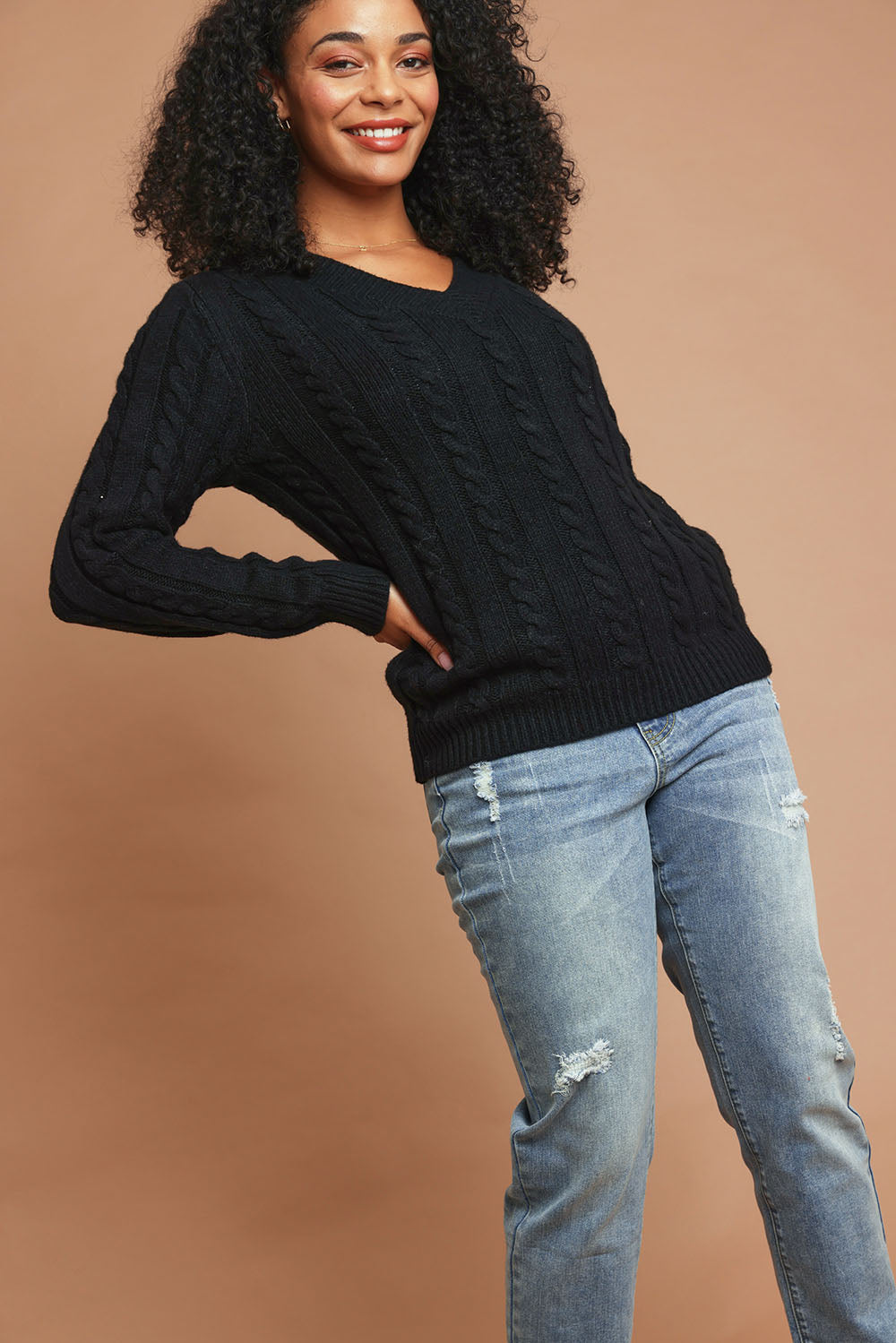 Model Ziara wearing size S of The V Neck Cable Knit Jumper in colour Black (Black), from the front, showing the whole outfit
