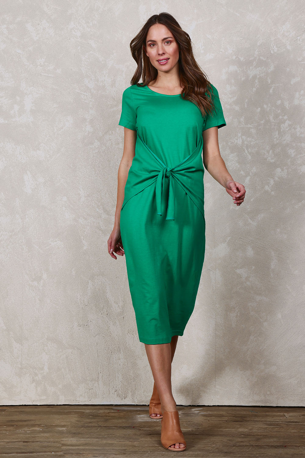 Model Madeline wearing size 10 of The Short Sleeve Tie Waist Dress in colour Emerald (Green), from the front, showing the whole outfit