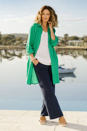 Model Emma wearing size 10 of The Double Cotton Long Overshirt in colour Emerald (Green), from the front, showing the whole outfit