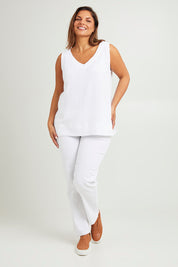 Model Monique wearing size 14 of The Double Cotton V Tank in colour White (White), from the front, showing the whole outfit