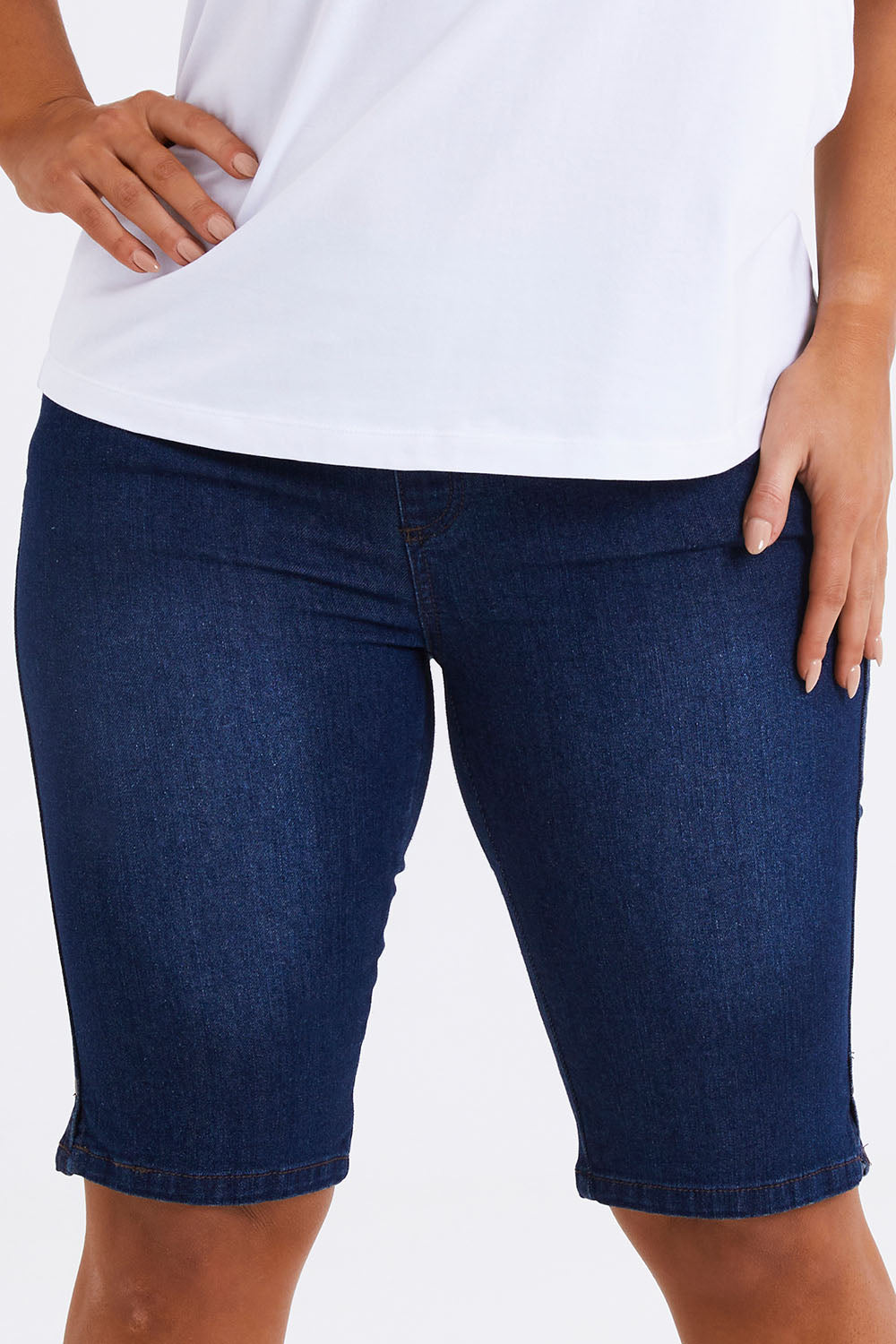 Model Monique wearing size 14 of The Pull On Denim Short in colour Darkdenim (Blue), from the front, cropped image
