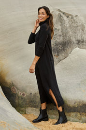 Model Amanda wearing size S of The Roll Neck Knit Maxi Dress in colour Black (Black), from the front, showing the whole outfit