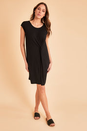 Model Madeline wearing size 10 of The Luxe Twist Detail Tee Dress in colour Black (Black), from the front, showing the whole outfit