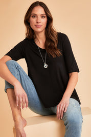 Model Madeline wearing size 10 of The Luxe A Line Tee in colour Black (Black), from the front, showing the whole outfit