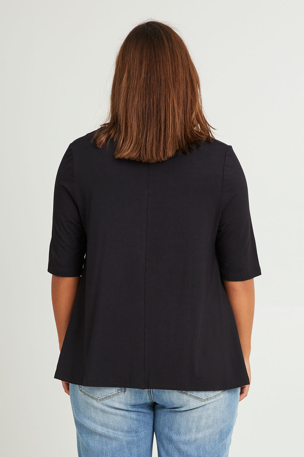 Model Monique wearing size 14 of The Luxe A Line Tee in colour Black (Black), from the back