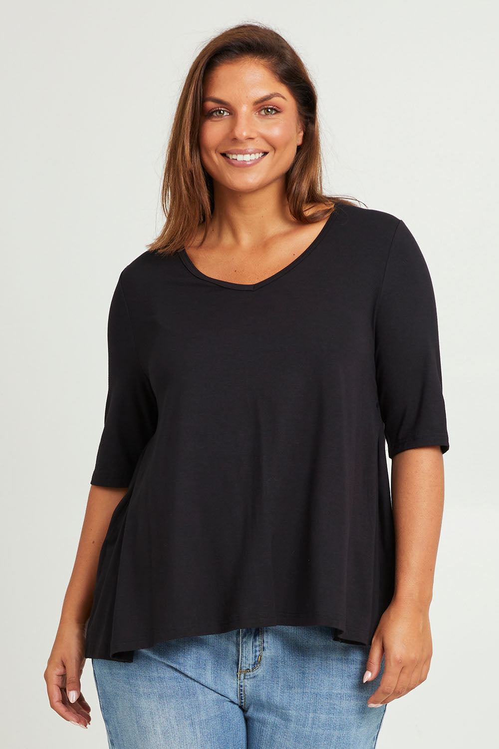 Model Monique wearing size 14 of The Luxe A Line Tee in colour Black (Black), from the front, cropped image
