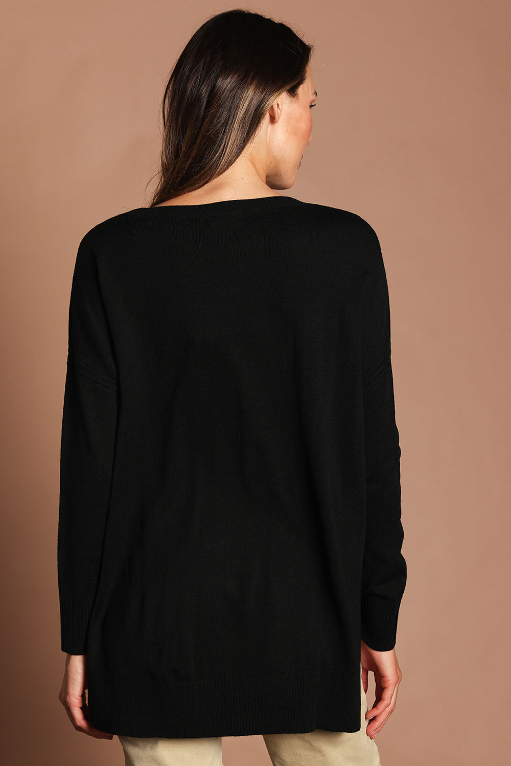 Model Madeline wearing size S of The High Low V Neck Jumper in colour Black (Black), from the back