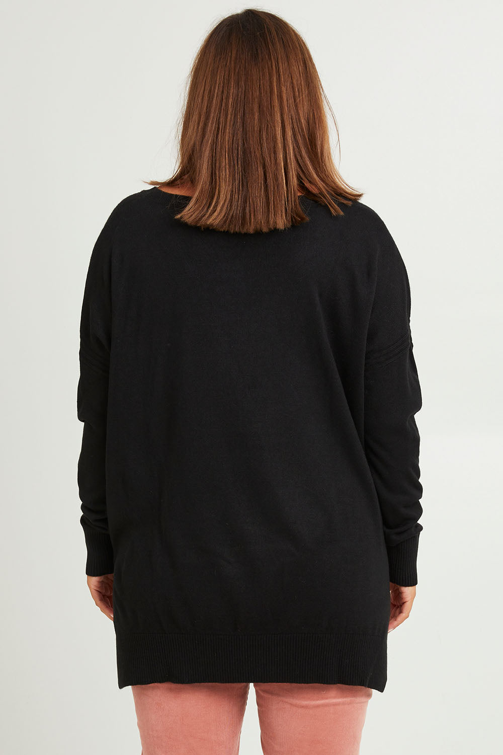 Model Monique wearing size L of The High Low V Neck Jumper in colour Black (Black), from the back