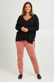 Model Monique wearing size L of The High Low V Neck Jumper in colour Black (Black), from the front, showing the whole outfit