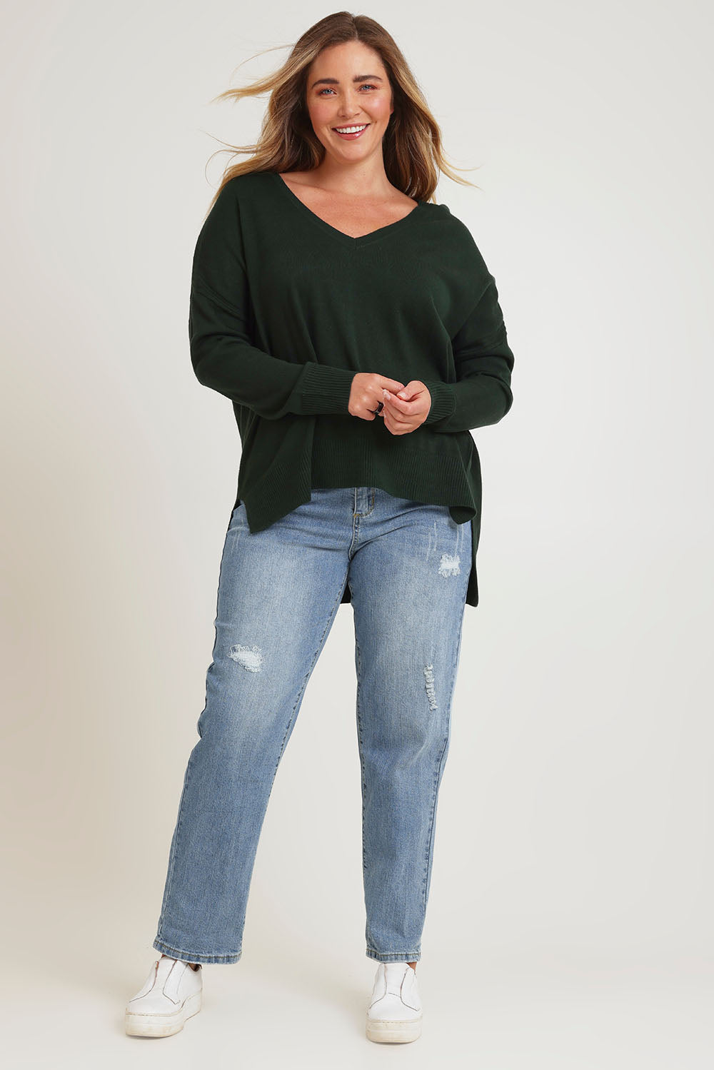 Model Chanel wearing size XL of The High Low V Neck Jumper in colour Forest (Green), from the front, showing the whole outfit