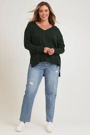 Model Chanel wearing size XL of The High Low V Neck Jumper in colour Forest (Green), from the front, showing the whole outfit