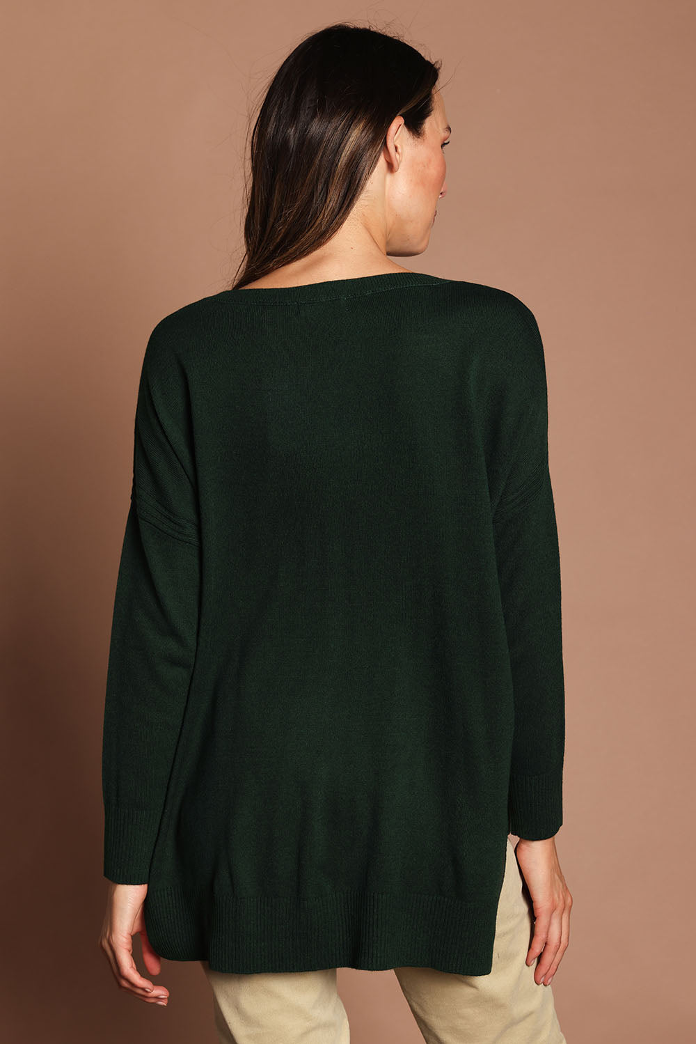 Model Madeline wearing size S of The High Low V Neck Jumper in colour Forest (Green), from the back